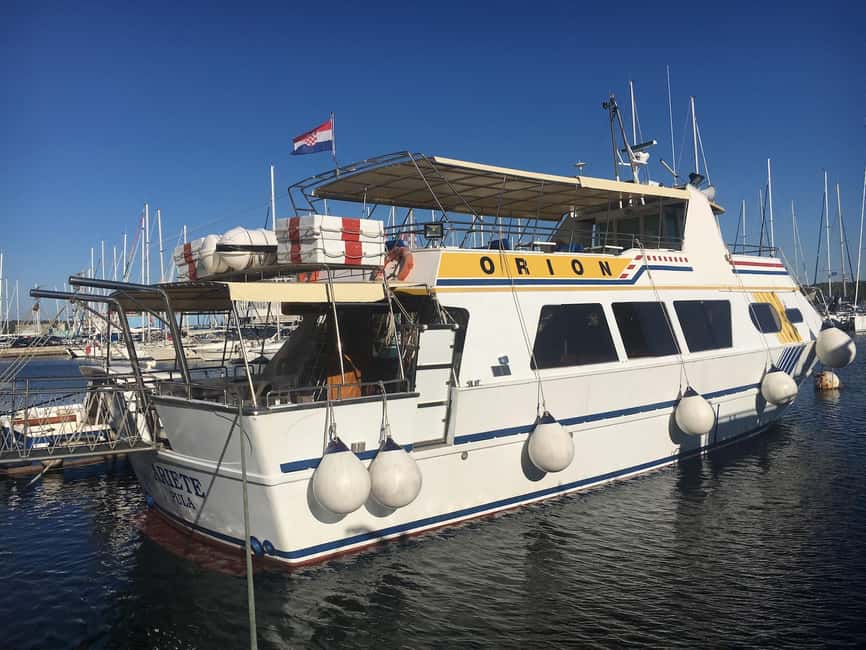 Pula: Dolphin Watching Sunset Cruise with Dinner & Drinks - Leaving Pula harbor with the amphitheater behind you